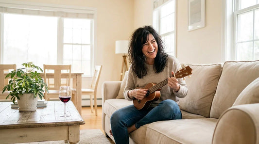 Woman laughing with surprise playing ukulele for the first time, ukulele beginner adult