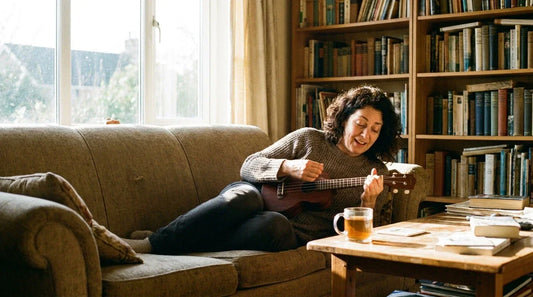 Adult woman smiling playing ukulele confidently at home, beginner progress